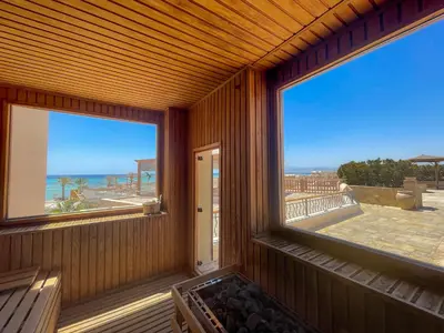 a room with a large window with a view of the ocean at The Breakers Diving and Surfing Lodge Soma Bay in Hurghada