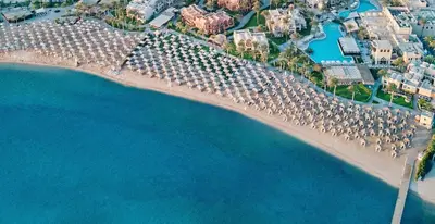 an aerial view of a beach with umbrellas and the water at JAZ Makadina in Hurghada