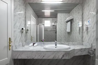 a white bathroom with a sink and a mirror at Eagles Paradise Abu Soma Resort in Hurghada