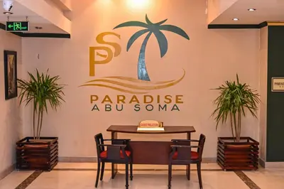 a sign for a restaurant with a palm tree on a wall at Eagles Paradise Abu Soma Resort in Hurghada