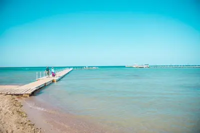 a group of people walking on a pier over the water at Pharaoh Azur Resort in Hurghada