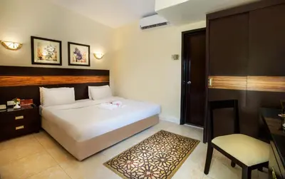 a bedroom with a white bed and a chair at Obelisk Nile Hotel Aswan in Aswan