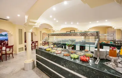 a buffet in a restaurant with food on display at Obelisk Nile Hotel Aswan in Aswan