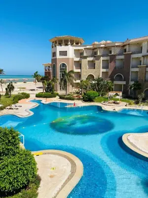 a resort with a large swimming pool next to the beach at Royal Beach Serviced Apartments in Hurghada