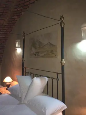 a bedroom with a bed with white pillows on it at Qasr El Bagawat Hotel in ‘Ezbet Halfa