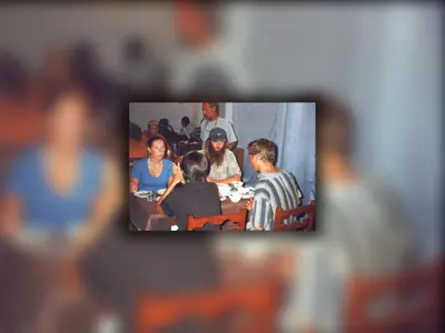 a tv screen with a group of people sitting at a table at Anglo Hotel in Luxor