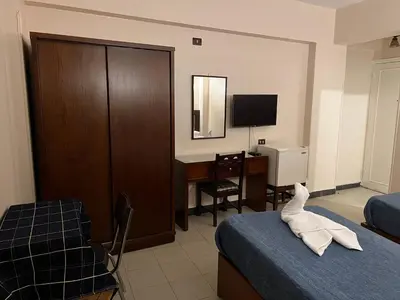 a hotel room with a bed and a desk with a computer at Anglo Hotel in Luxor