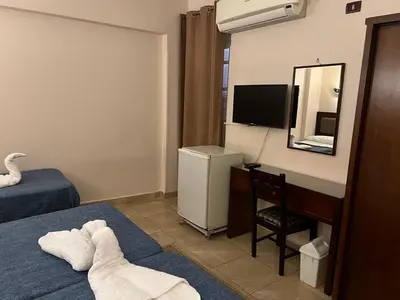 a hotel room with a bed and a desk with a mirror at Anglo Hotel in Luxor