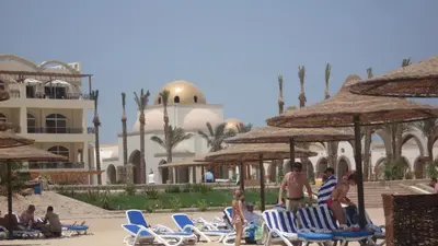 a group of people sitting in lawn chairs at a resort at Palm Beach Apartments 302B in Hurghada