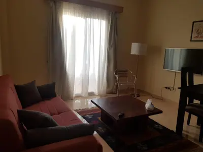 a living room with a red couch and a table at Palm Beach Apartments 302B in Hurghada