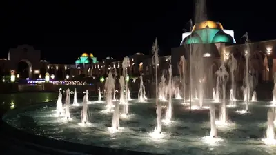 a fountain in front of a building at night at Palm Beach Apartments 302B in Hurghada