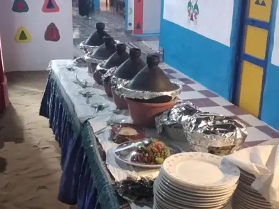 a table with a blue table cloth with a line of food at Fadlos Anay Nubian Guesthouse فضلوس أناي in Aswan