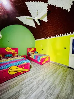 a bedroom with two beds in a room with a ceiling at Fadlos Anay Nubian Guesthouse فضلوس أناي in Aswan