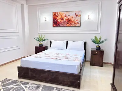a bedroom with a bed with a painting on the wall at Full Moon House in Luxor