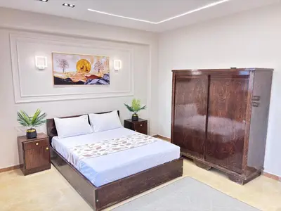 a bedroom with a bed and a painting on the wall at Full Moon House in Luxor