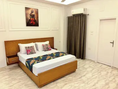a bedroom with a bed and a painting on the wall at Full Moon House in Luxor