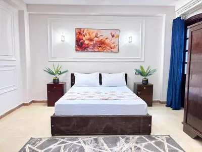 a bedroom with a bed and a painting on the wall at Full Moon House in Luxor