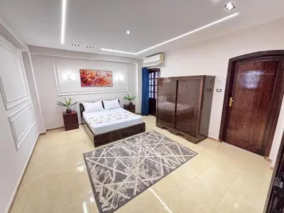 a bedroom with a bed and a door and a rug at Full Moon House in Luxor