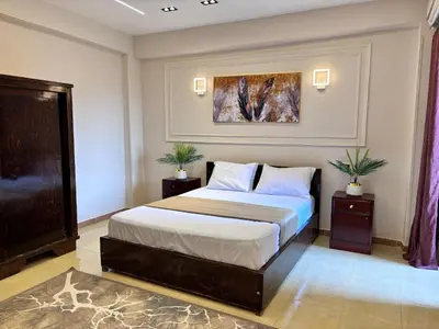 a bedroom with a bed and a painting on the wall at Full Moon House in Luxor