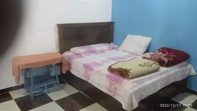 a small bedroom with a bed and a table at Al Salam Camp in Luxor