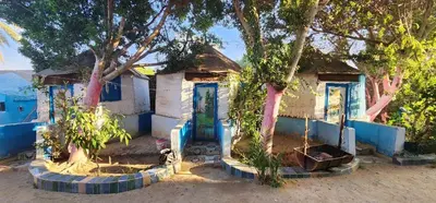 a blue and white house with trees in front of it at Al Salam Camp in Luxor