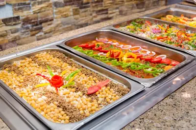 a buffet line with trays of different types of vegetables at Coral Sun Beach in Safaga