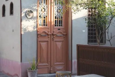 a large wooden door on a building with a fence at Villa Nile House Luxor in Luxor