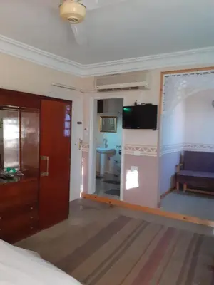 a room with a bed and a television and a couch at Villa Nile House Luxor in Luxor