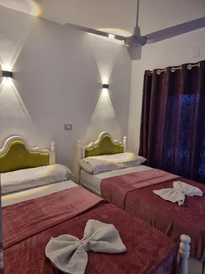 two beds in a room with towels on them at Baba Dool in Aswan