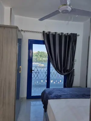 a bedroom with a window with a view of the water at Baba Dool in Aswan