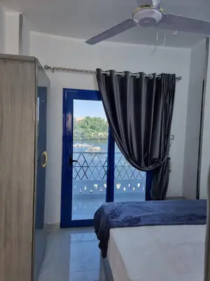 a bedroom with a blue door and a window at Baba Dool in Aswan
