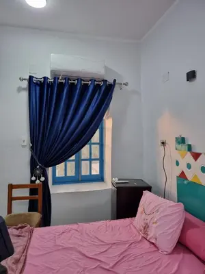 a bedroom with a bed and a blue curtain at Baba Dool in Aswan
