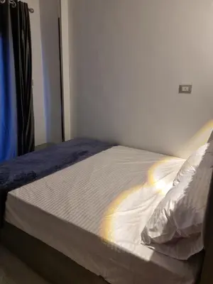 a bed with white sheets and a blue blanket at Baba Dool in Aswan
