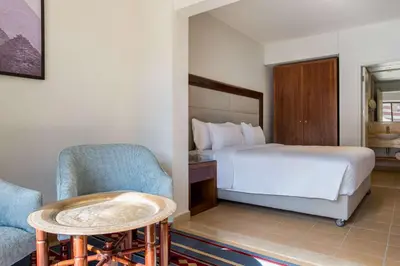 a bedroom with a bed and a chair and a table at Marina Resort Port Ghalib, a member of Radisson Individuals in Port Ghalib