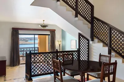 a dining room with a table and chairs and a staircase at Marina Resort Port Ghalib, a member of Radisson Individuals in Port Ghalib