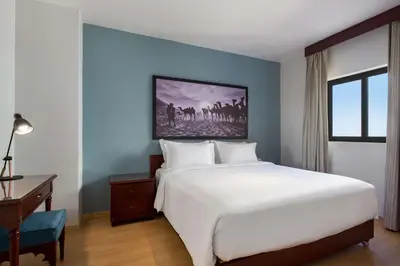 a bedroom with a large white bed and a desk at Marina Resort Port Ghalib, a member of Radisson Individuals in Port Ghalib