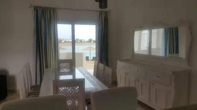 a dining room with a mirror and a table and chairs at Twin Lagoon Apartment at White Villas El Gouna in Hurghada
