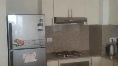 a kitchen with a stainless steel refrigerator and a stove at Twin Lagoon Apartment at White Villas El Gouna in Hurghada
