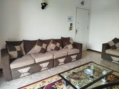 a living room with a brown couch and a table at Luxor Star Apartments in Luxor