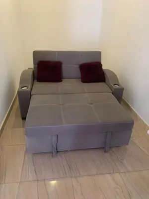 a couch with two red pillows sitting in a room at Villa Elhag Nile View in Luxor