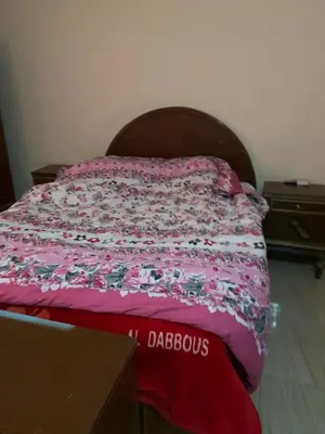 a bed in a bedroom with a pink bedspread with flowers at Villa Elhag Nile View in Luxor