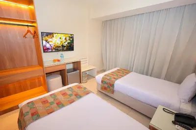 a hotel room with two beds and a tv at Hapi Hotel in Aswan