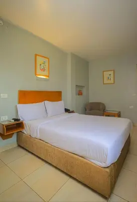 a bedroom with a large white bed and a chair at Hapi Hotel in Aswan