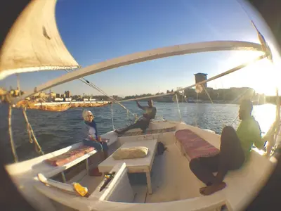 a group of people sitting on a boat in the water at The Mango Guest House in Aswan