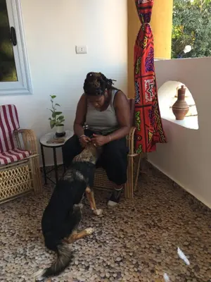 a woman sitting in a room with a dog at The Mango Guest House in Aswan