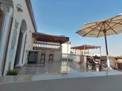 a patio with an umbrella and tables and chairs at Luxor palace Apartments in Luxor