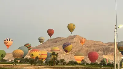 a bunch of hot air balloons flying in the sky at Luxor palace Apartments in Luxor