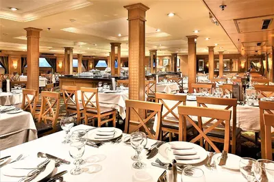 a dining room with tables and chairs with white table settings at JAZ Crown Jubilee Nile Cruise - Every Thursday from Luxor for 07 & 04 Nights - Every MondayFrom Aswan for 03 Nights in Luxor