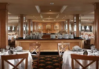 a restaurant with two tables with white tablecloths and a kitchen at JAZ Crown Jubilee Nile Cruise - Every Thursday from Luxor for 07 & 04 Nights - Every MondayFrom Aswan for 03 Nights in Luxor