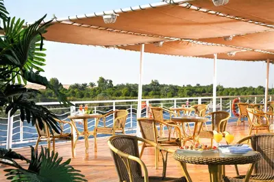 a deck with tables and chairs on a cruise ship at JAZ Crown Jubilee Nile Cruise - Every Thursday from Luxor for 07 & 04 Nights - Every MondayFrom Aswan for 03 Nights in Luxor